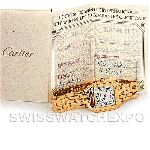 The image shows a Cartier Panthere W25014B9 Men
s Yellow Gold Silver Dial W25014B9 Men
s Yellow Gold Silver Dial watch and its international guarantee certificate positioned at an angle.