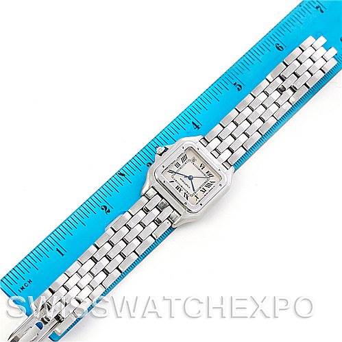 The image shows a top-down view of a Cartier Panthere W25054P5 Men
s Stainless Steel Silver Dial W25054P5 Men
s Stainless Steel Silver Dial watch with its face and bracelet laid next to a blue ruler for scale.