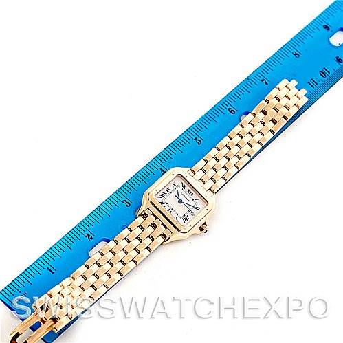 This image shows a Cartier Panthere W25014B9 Men's Yellow Gold Silver Dial W25014B9 Men's Yellow Gold Silver Dial model watch laid flat next to a blue ruler, highlighting its length and design.