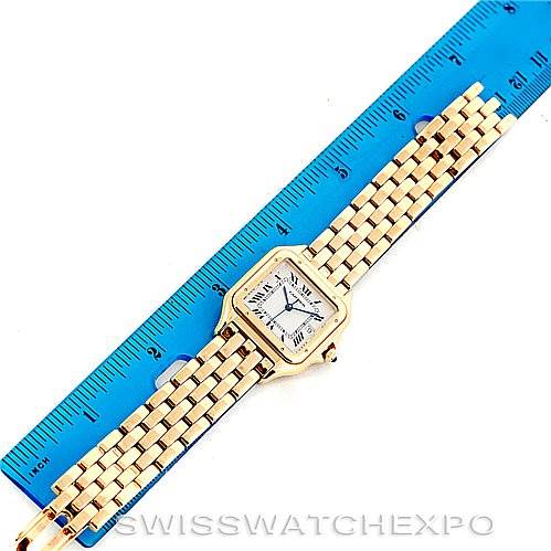 This image shows a top-down view of a Cartier Panthere W25014B9 Men
s Yellow Gold Silver Dial W25014B9 Men
s Yellow Gold Silver Dial watch, featuring its face, bezel, and bracelet alongside a blue ruler for scale.