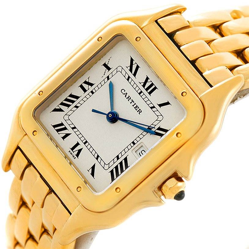 This image shows a close-up of the face and part of the gold bracelet of the Panthère model by Cartier.