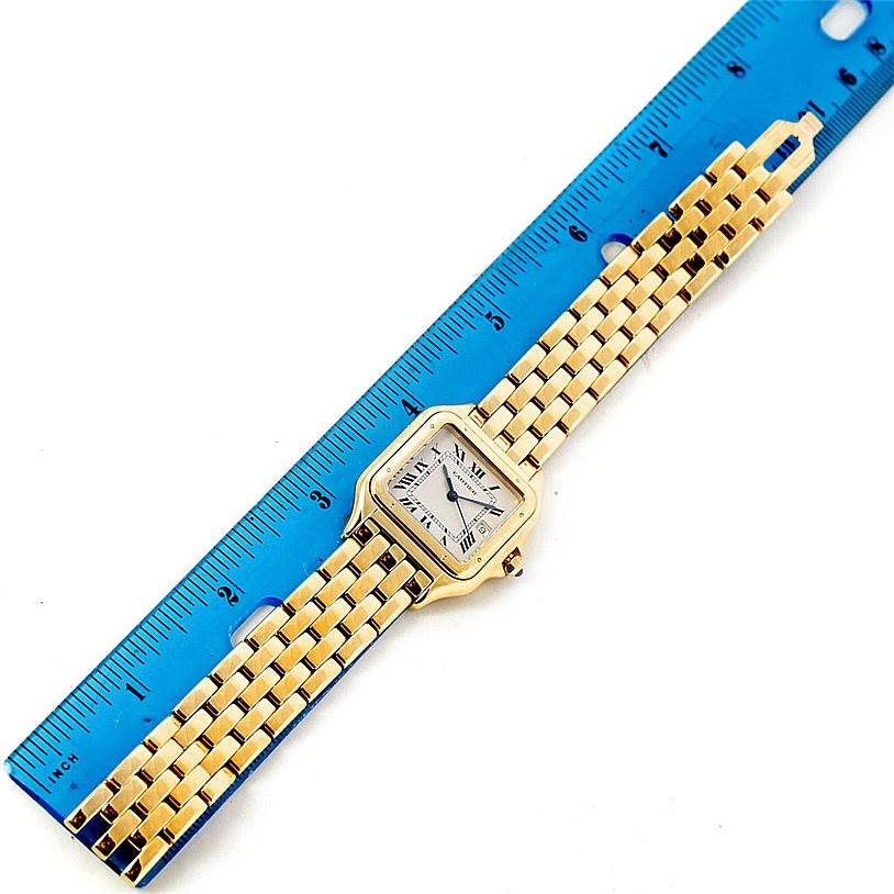 The image shows a Cartier Panthere W25014B9 Men's Yellow Gold Silver Dial W25014B9 Men's Yellow Gold Silver Dial watch laid flat next to a blue ruler, displaying the face and entire bracelet.