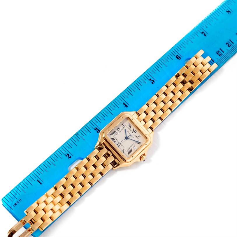 The image shows an overhead view of a Cartier Panthere W25014B9 Men's Yellow Gold Silver Dial W25014B9 Men's Yellow Gold Silver Dial watch next to a blue ruler.