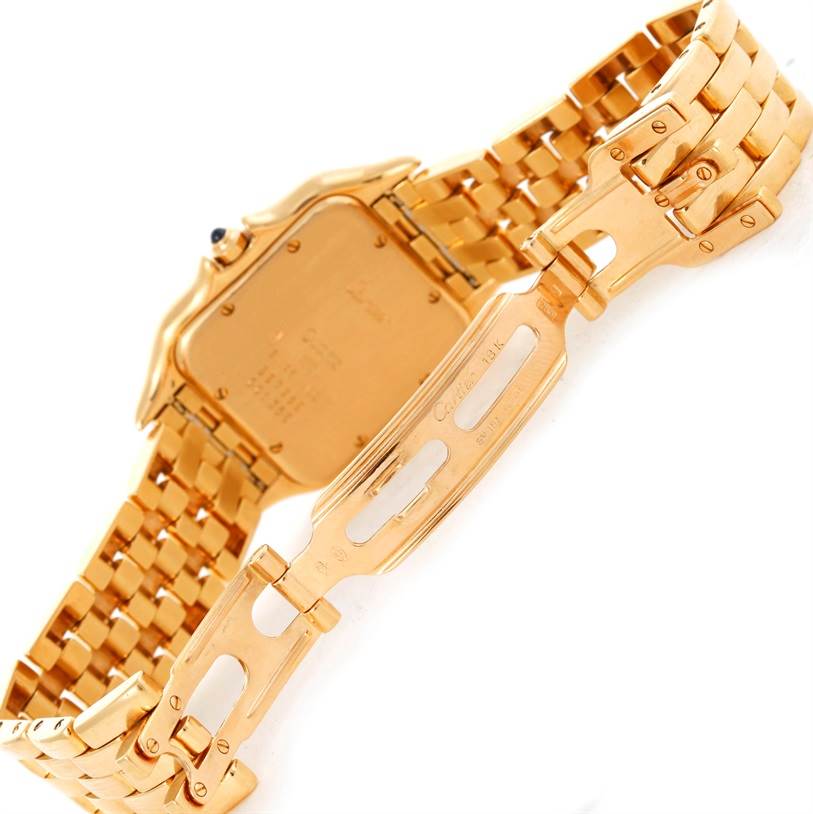The image shows the back and clasp of a Cartier Panthère watch at an angle highlighting its golden metal band.