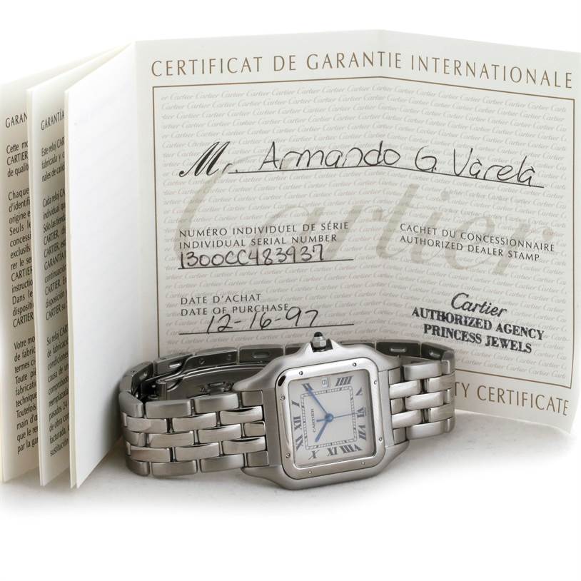 The image shows a Cartier Panthere W25032P5 Men
s Stainless Steel Silver Dial W25032P5 Men
s Stainless Steel Silver Dial watch lying flat with its warranty certificate in the background.