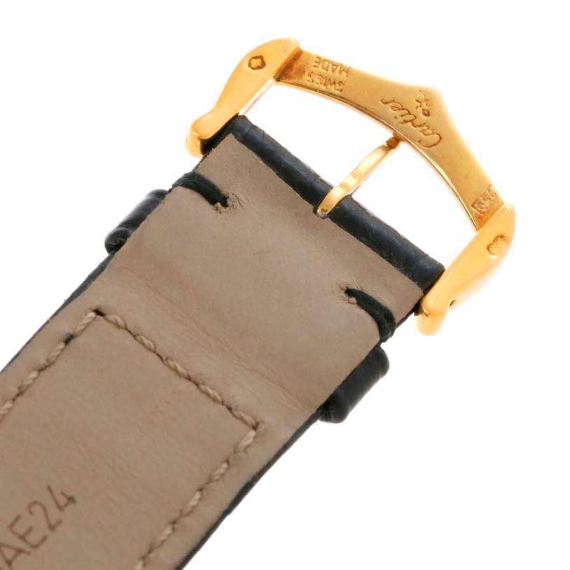 This image shows the buckle and part of the leather strap of a Cartier Tank Classic Men's Yellow Gold Silver Dial Men's Yellow Gold Silver Dial watch up close.