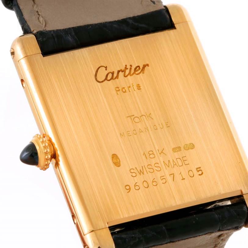 This image shows the back of a Cartier Tank Classic Men's Yellow Gold Silver Dial Men's Yellow Gold Silver Dial watch, highlighting the gold case, inscriptions, and part of the leather strap.
