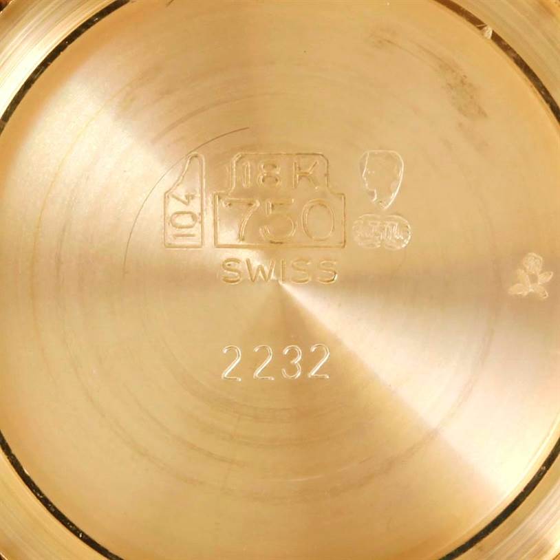 This image shows the engraved back case of a Cartier Tank Classic Men's Yellow Gold Silver Dial Men's Yellow Gold Silver Dial watch, indicating it is 18K gold and Swiss-made.