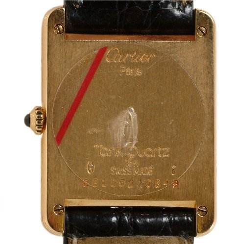 The image shows the back case of a Cartier Tank Classic Men
s Steel and Gold (two tone) White Dial Men
s Steel and Gold (two tone) White Dial watch along with parts of the leather strap.