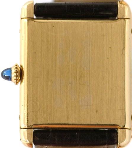 This image shows a close-up of the back case and crown of a Cartier Tank Classic Yellow Gold White Dial Yellow Gold White Dial watch.