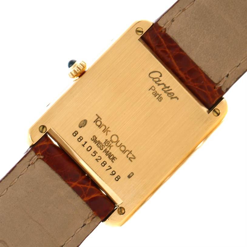 This image shows the back of a Cartier Tank Classic Men
s Yellow Gold White Dial Men
s Yellow Gold White Dial model watch with engravings and brown leather straps visible.