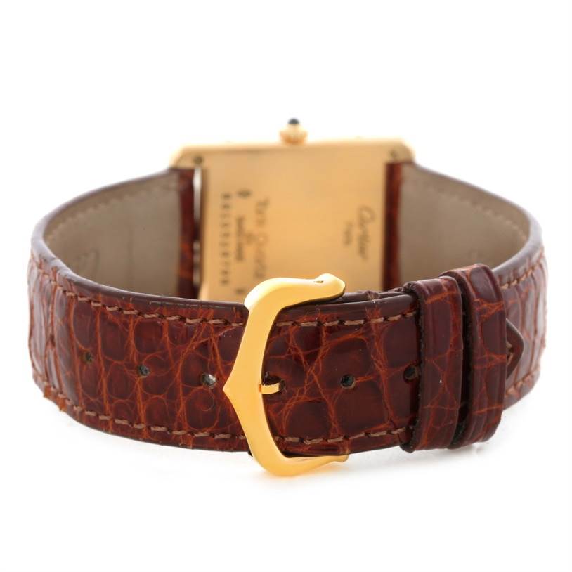 This image shows the back of the Cartier Tank Classic Men
s Yellow Gold White Dial Men
s Yellow Gold White Dial watch, highlighting its leather strap and gold buckle.