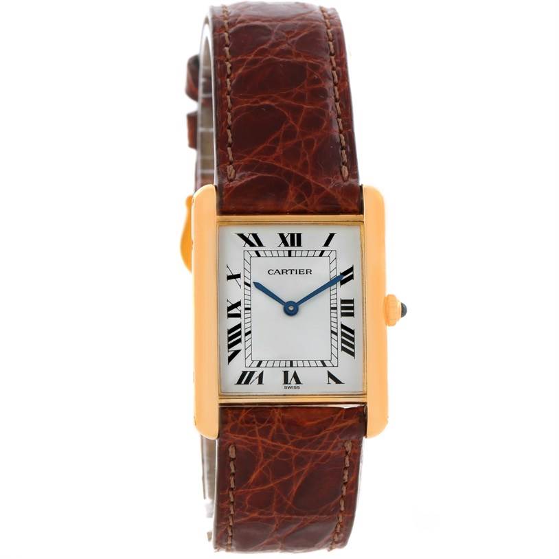 The image shows a Cartier Tank Classic Men
s Yellow Gold White Dial Men
s Yellow Gold White Dial watch from a front angle, highlighting its rectangular gold case, Roman numeral dial, and brown leather strap.