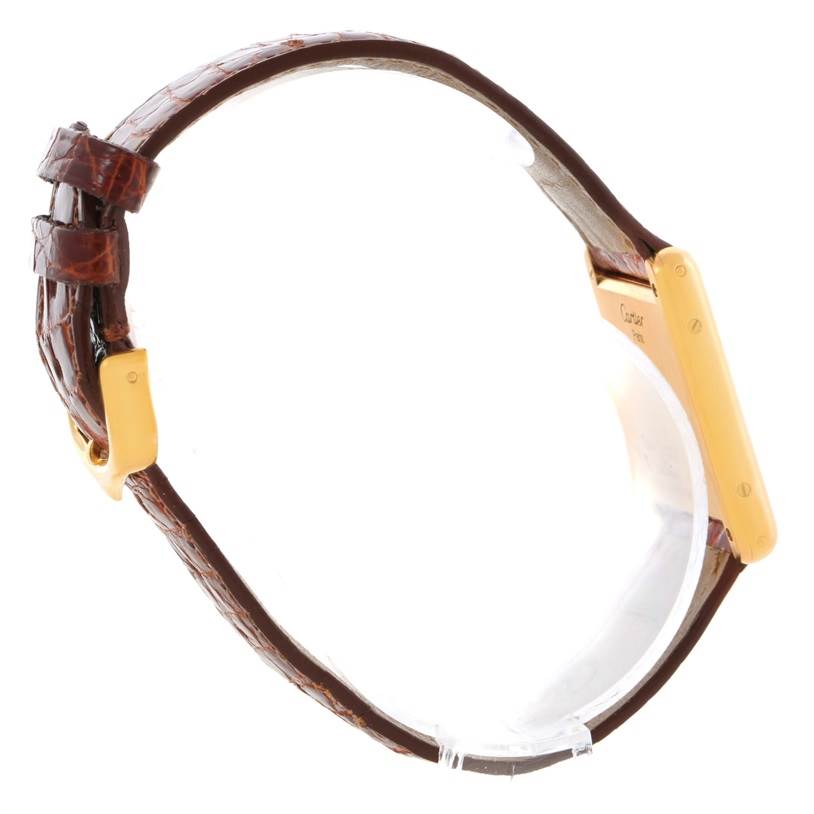 The image shows a side view of a Cartier Tank Classic Men
s Yellow Gold White Dial Men
s Yellow Gold White Dial watch including its brown leather strap and gold case.