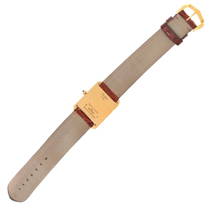 The image shows the back view of a Cartier Tank Classic Men
s Yellow Gold White Dial Men
s Yellow Gold White Dial watch, featuring its strap and the case back details.