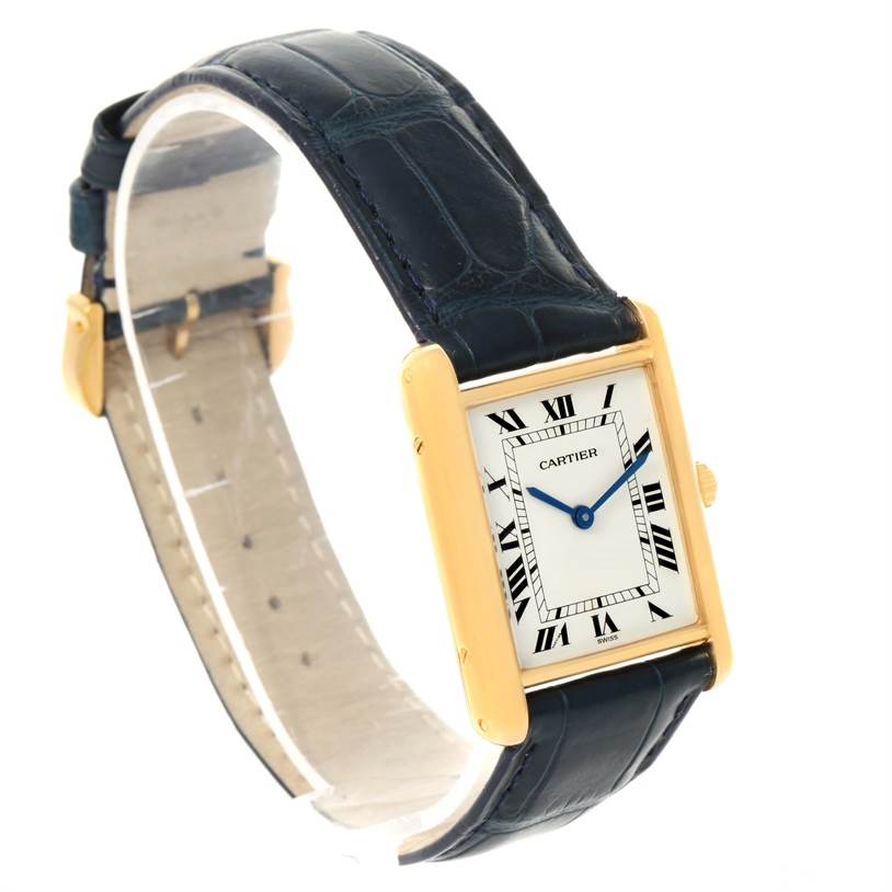 The image shows a Cartier Tank Classic Men's Yellow Gold White Dial Men's Yellow Gold White Dial watch from an angled side view, highlighting its rectangular face, Roman numeral dial, and leather strap.