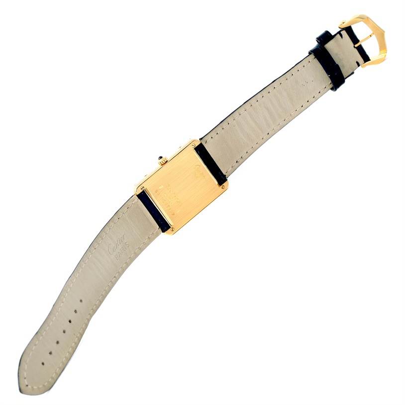 The image shows the back of a Cartier Tank Classic Men's Yellow Gold White Dial Men's Yellow Gold White Dial watch, highlighting its strap and gold case.