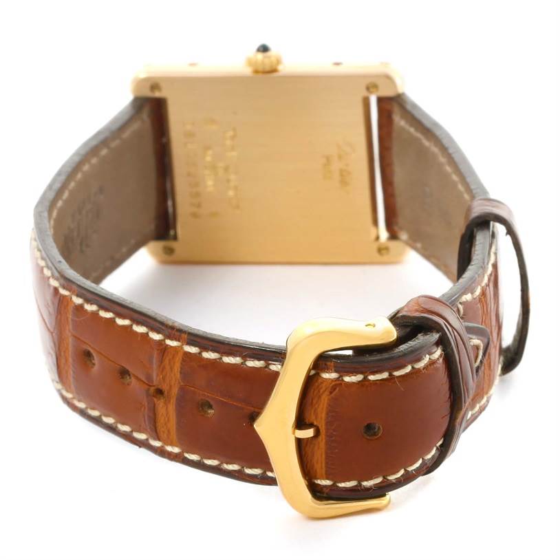 The image shows the Cartier Tank Classic Yellow Gold White Dial Yellow Gold White Dial watch from the back, highlighting the leather strap and gold buckle.