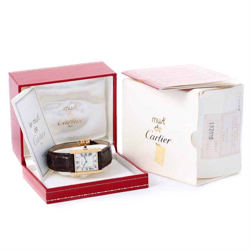 The image shows a Cartier Tank Classic Yellow Gold Silver Dial Yellow Gold Silver Dial watch at a front angle, inside its open box with accompanying accessories.