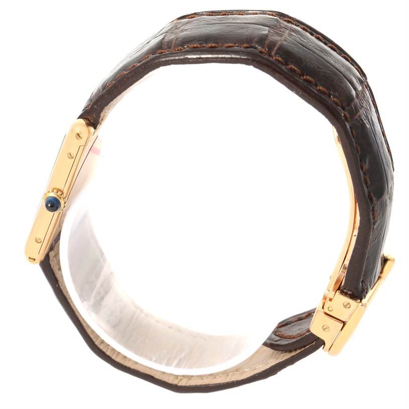 This image shows a side angle of the Cartier Tank Classic Yellow Gold Silver Dial Yellow Gold Silver Dial watch with a close-up of the strap, buckle, and crown.