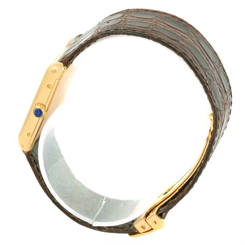 This image shows a side view of the Cartier Tank Classic Men
s Yellow Gold White Dial Men
s Yellow Gold White Dial watch, highlighting the crown and part of the strap.