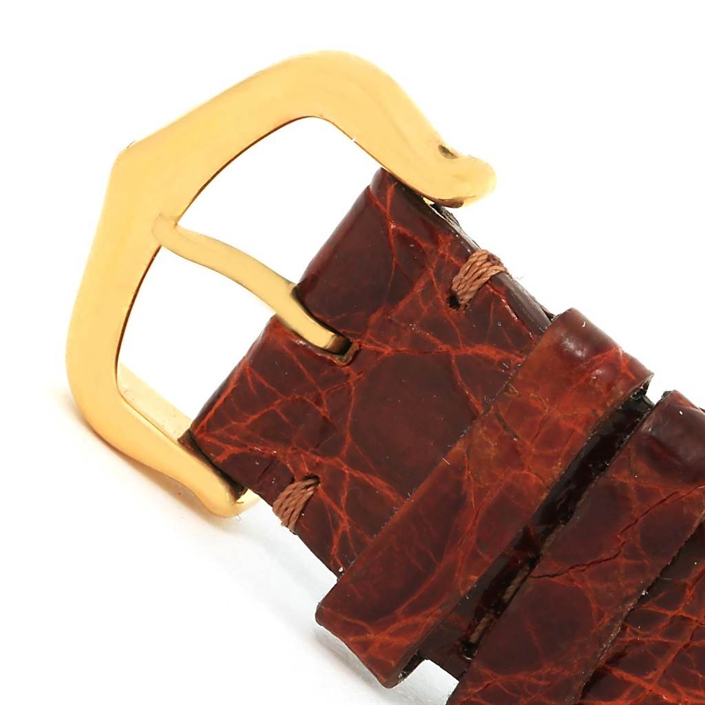 The image shows a close-up of the leather strap end and gold buckle of the Cartier Tank Classic Yellow Gold White Dial Yellow Gold White Dial watch.