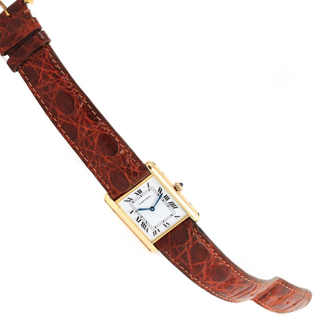 The image shows a side view of a Cartier Tank Classic Yellow Gold White Dial Yellow Gold White Dial watch featuring its rectangular dial and a brown leather strap.