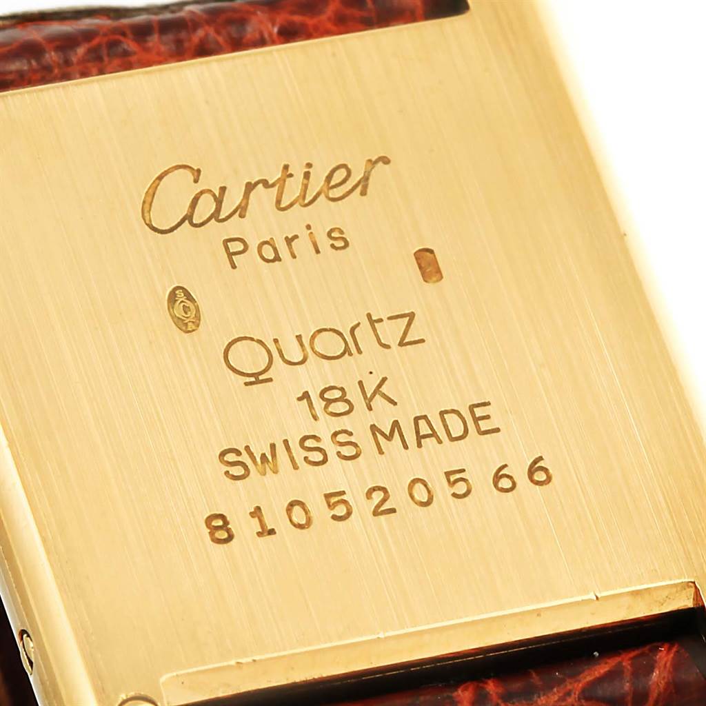 The image shows the engraved caseback of a Cartier Tank Classic Yellow Gold White Dial Yellow Gold White Dial watch, highlighting details such as "Quartz," "18K," and "Swiss Made."