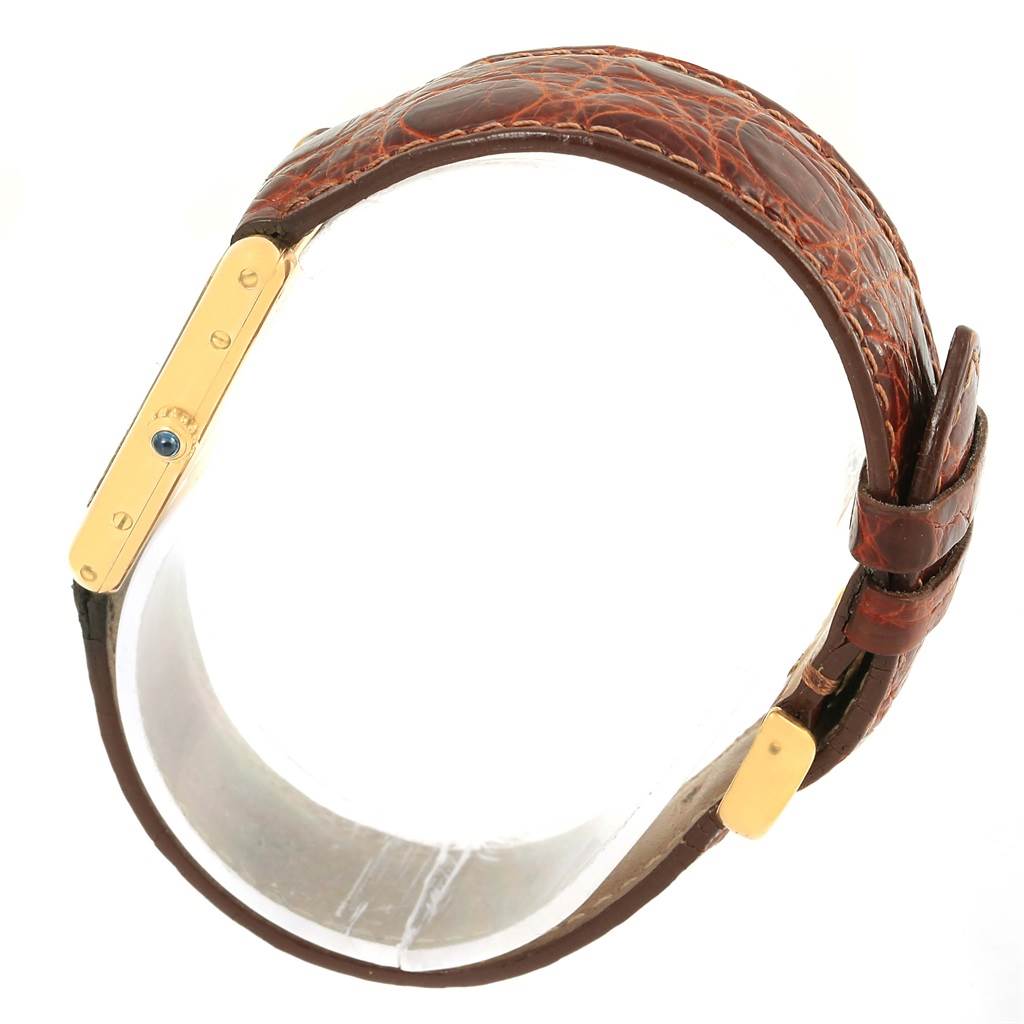 This image shows a side view of a Cartier Tank Classic Yellow Gold White Dial Yellow Gold White Dial watch highlighting its brown leather strap and gold casing.