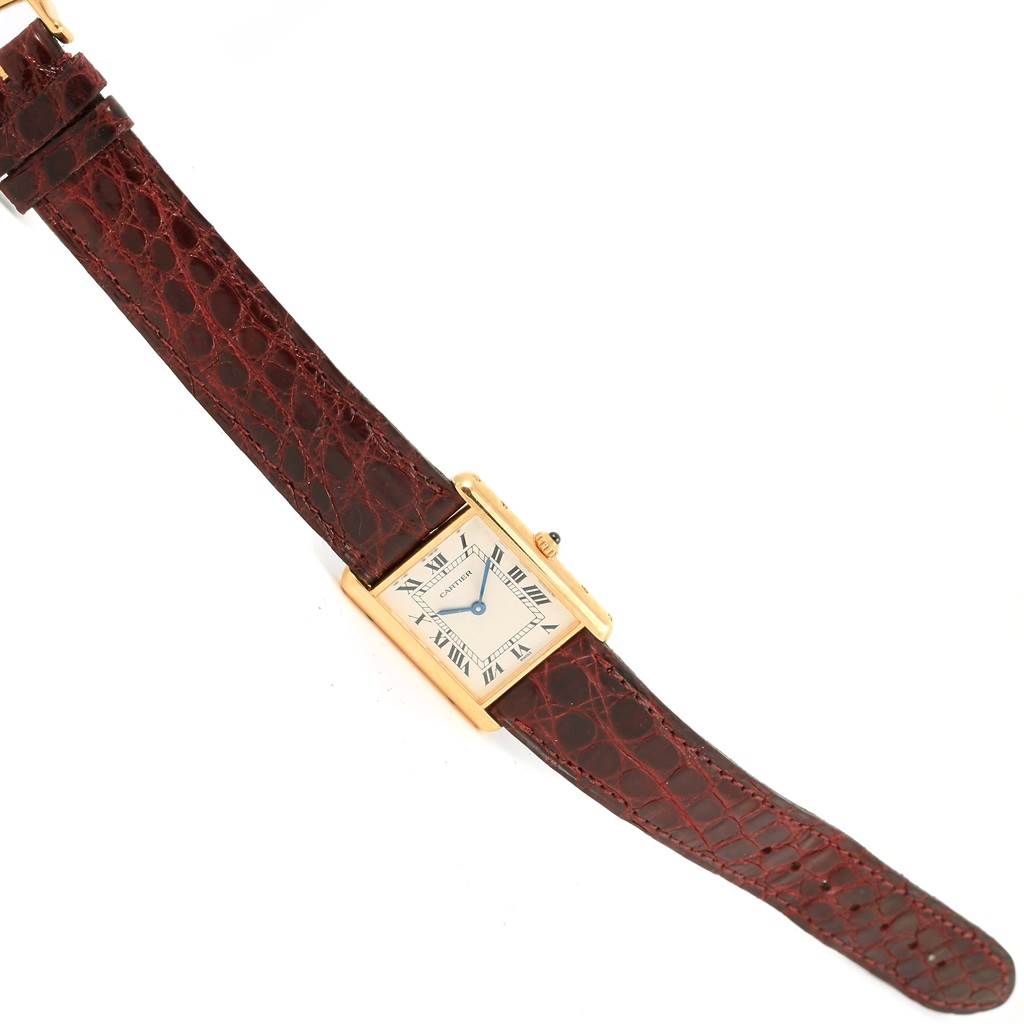 The Cartier Tank Classic 1140 Yellow Gold White Dial 1140 Yellow Gold White Dial watch is shown at an angled, aerial view, displaying the face, case, and leather strap.