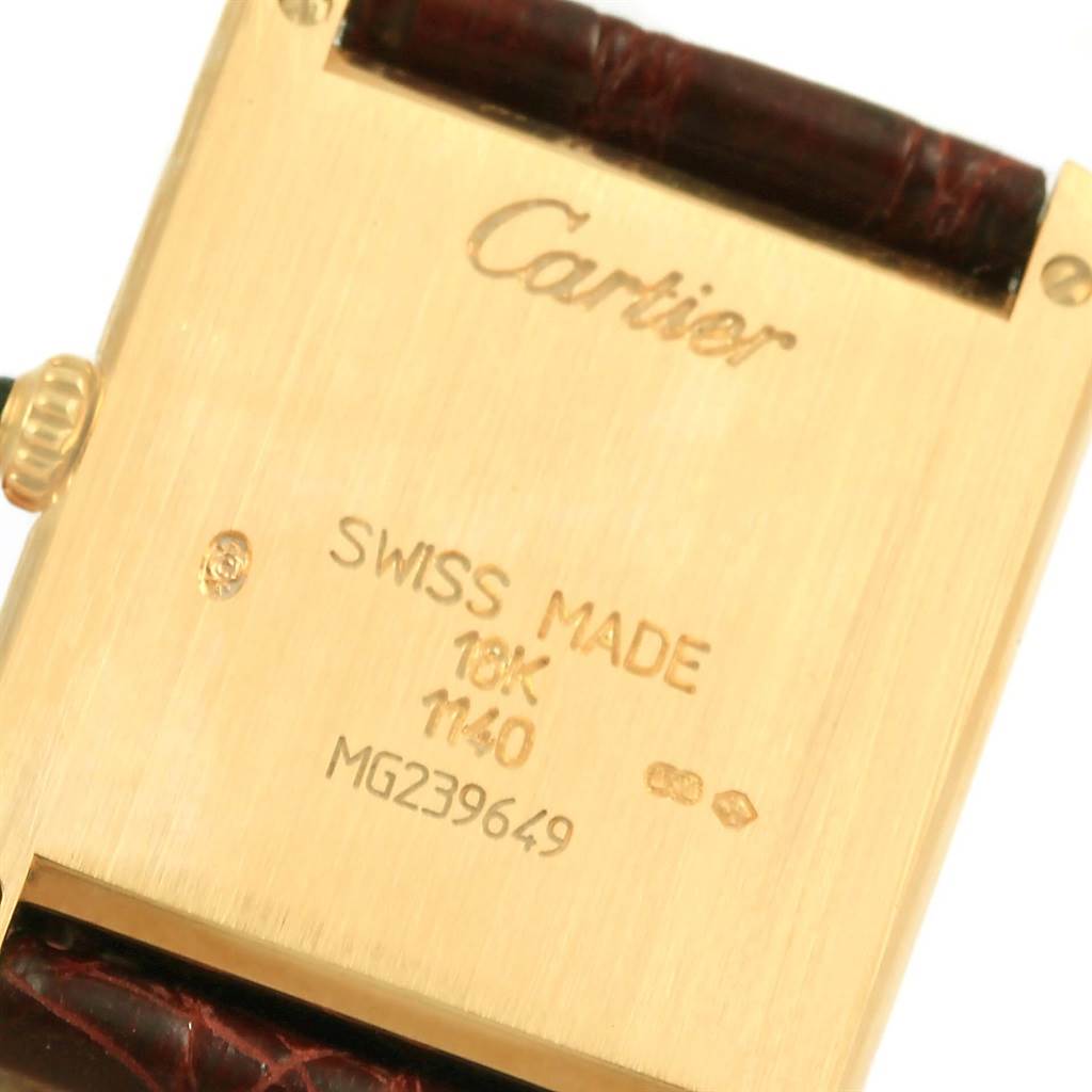 This image shows the case back and part of the leather strap of a Tank Classic model by Cartier.