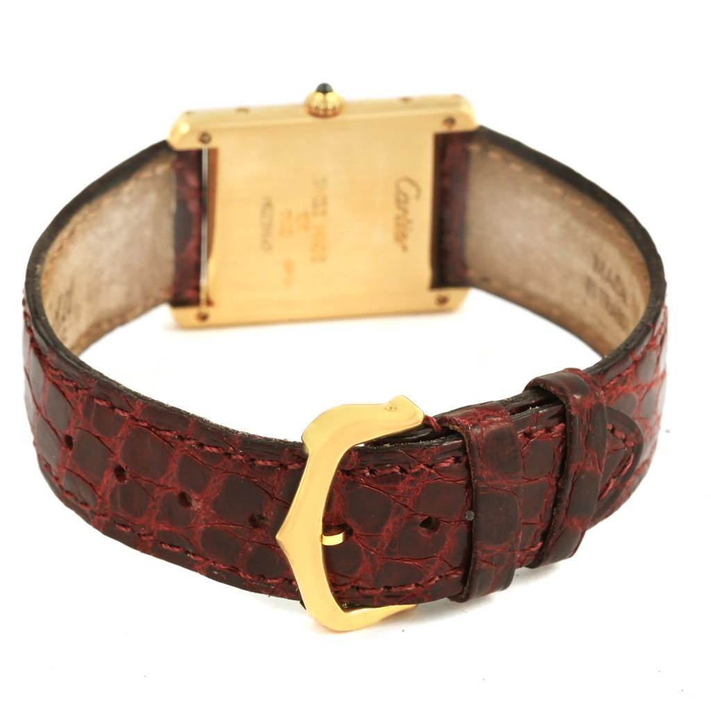 The image shows the back of the Cartier Tank Classic 1140 Yellow Gold White Dial 1140 Yellow Gold White Dial watch and its leather strap with a gold buckle.