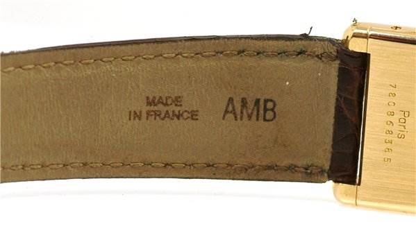 This close-up image shows the inside of the leather strap and part of the gold casing of a Cartier Tank Classic Men's Yellow Gold White Dial Men's Yellow Gold White Dial watch.