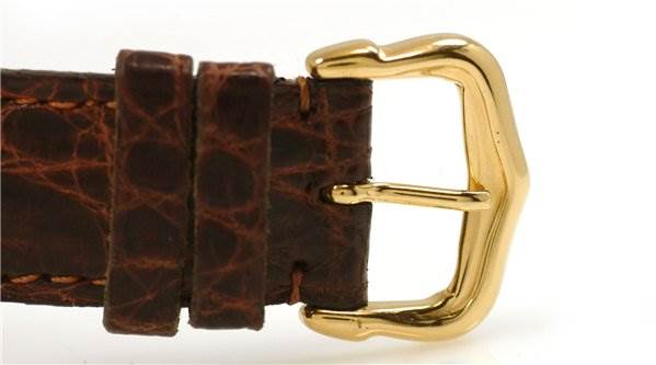 This image shows a close-up of the brown leather strap and gold buckle of a Cartier Tank Classic Men's Yellow Gold White Dial Men's Yellow Gold White Dial watch.