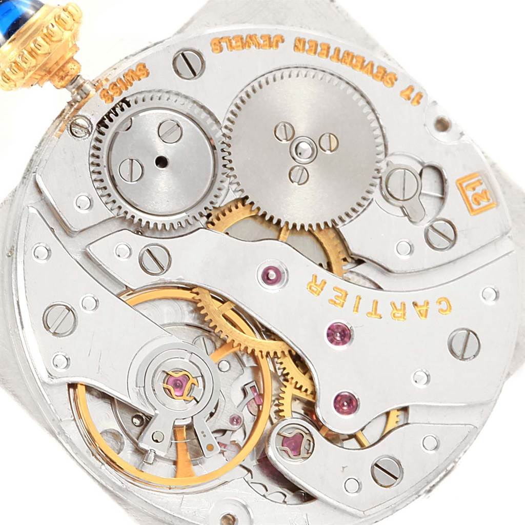 This close-up image shows the intricate inner mechanics of a Tank Classic model by Cartier, focusing on the gears and movement.