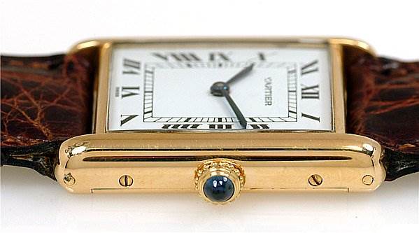 The image shows a side angle of the Cartier Tank Classic Women's Yellow Gold White Dial Women's Yellow Gold White Dial watch, highlighting the crown and part of the leather strap.