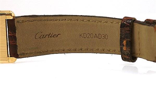 This image shows the underside of the strap with the Cartier logo and serial number for a Tank Classic model watch by Cartier.