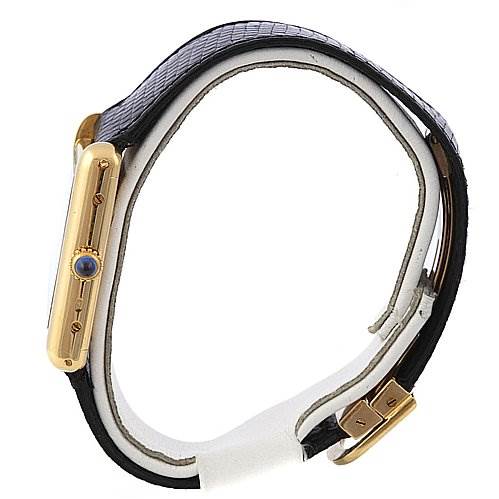 The image shows a side view of the Cartier Tank Classic Yellow Gold White Dial Yellow Gold White Dial watch, highlighting the case and strap with an ornate crown.