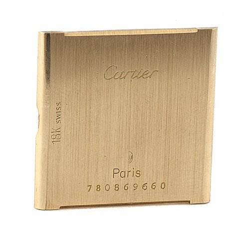 This image shows the back case of a Cartier Tank Classic Yellow Gold White Dial Yellow Gold White Dial watch, displaying the brand name, model, and serial number.