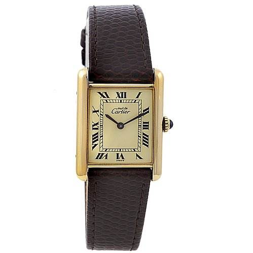 The Cartier Tank Classic Yellow Gold Beige Dial Yellow Gold Beige Dial watch is shown from a front angle, displaying its rectangular dial, Roman numerals, and brown leather strap.