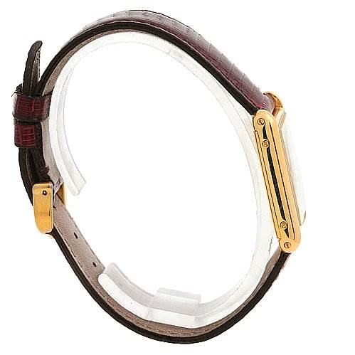 This image shows a side profile of the Cartier Tank Classic Yellow Gold White Dial Yellow Gold White Dial watch, highlighting its gold casing and brown leather strap.