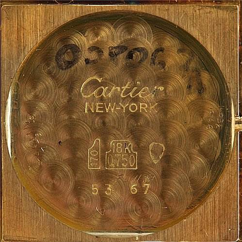This image shows the interior case back of a Cartier Tank Classic Yellow Gold White Dial Yellow Gold White Dial watch, highlighting the brand name, material markings, and serial number.