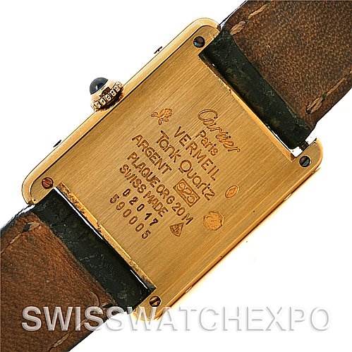 The image shows the back view of a Cartier Tank Classic Yellow Gold Champagne Dial Yellow Gold Champagne Dial watch, displaying engravings and the strap attachment.