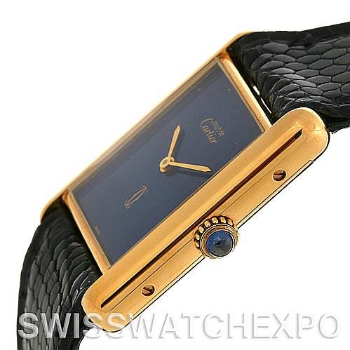 The image shows a side view of a Cartier Tank Classic Yellow Gold Blue Dial Yellow Gold Blue Dial watch, highlighting its gold case, crown, and part of the black leather strap.