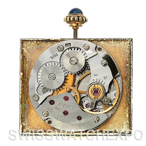 This image shows the movement and inner workings of a Cartier Tank Classic Yellow Gold Blue Dial Yellow Gold Blue Dial watch from a top-down angle.