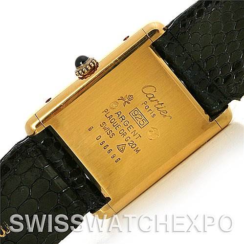 The image shows the back case of the Cartier Tank Classic Yellow Gold Blue Dial Yellow Gold Blue Dial watch, featuring branding and specifications.