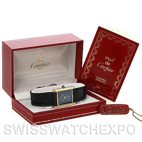 The image shows a Cartier Tank Classic Yellow Gold Blue Dial Yellow Gold Blue Dial watch displayed in its open box, with a booklet and a "Quartz" tag beside it.