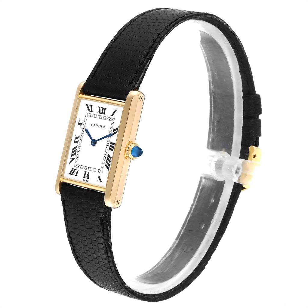 The image shows a Cartier Tank Classic  Men's Yellow Gold White Dial  Men's Yellow Gold White Dial model watch, focusing on the face, gold bezel, black leather strap, and blue sapphire crown.