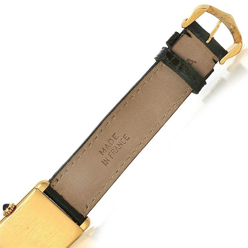 This image shows the underside of a Cartier Tank Classic Yellow Gold White Dial Yellow Gold White Dial watch and its leather strap with a "Made in France" stamp.