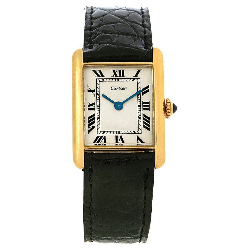 The image shows a frontal view of the Cartier Tank Classic Yellow Gold White Dial Yellow Gold White Dial watch, highlighting its rectangular face, Roman numerals, and black leather strap.